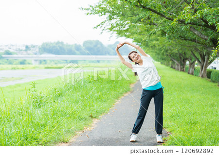 Senior woman stretching in the park Senior woman stretching in the park 120692892