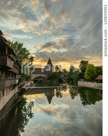 Schlayerturm medieval tower and Kettensteg (Chain Bridge) over river Pegnitz at sunset 120693001