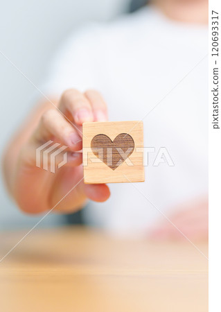 Hand holding heart block for health care, love, organ donation, charity, happy family, wellbeing and insurance concepts. world heart day, health day and mental health day Hand holding heart block for health care, love, organ donation, charity, happy family, wellbeing and insurance concepts. world heart day, health day and mental health day 120693317