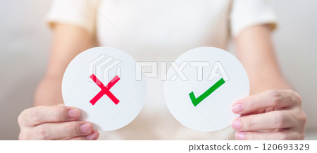 Woman show Wrong and Right symbol paper. True and false, accept and rejected, evaluation, Vote, Poll, Yes or No and Survey concepts 120693329