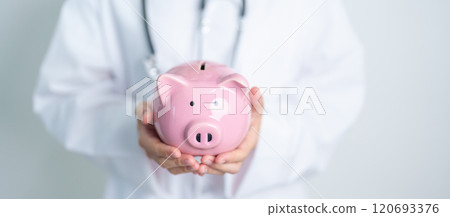 Doctor holding piggy bank and putting coin. and Healthcare cost, Money Saving, Health Insurance, Medical, Donation and Financial concepts 120693376