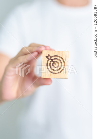 hand hold dartboard block with business goal, strategy, target, mission, action, objective, aim and success concept 120693397