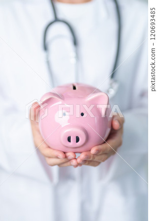 Doctor holding piggy bank and putting coin. and Healthcare cost, Money Saving, Health Insurance, Medical, Donation and Financial concepts 120693485