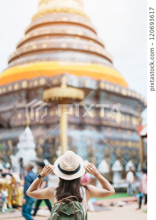 Young asian woman traveler in white dress with hat and bag traveling in Wat Phra That Lampang Luang, Tourist visit at Lampang, Thailand.. Asia Travel, Vacation and summer holiday concept 120693617