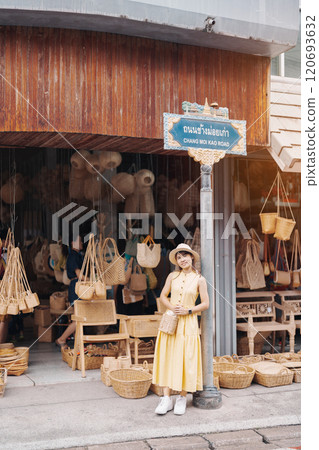 Young asian woman traveler in dress with hat traveling to wicker shop on Chang Moi Kao Road, Tourist visit at the old city in Chang Mai, Thailand. Asia Travel, Vacation and summer holiday concept Young asian woman traveler in dress with hat traveling to wicker shop on Chang Moi Kao Road, Tourist visit at the old city in Chang Mai, Thailand. Asia Travel, Vacation and summer holiday concept 120693632