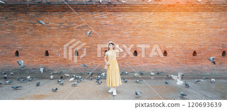 Young asian woman traveler in Yellow dress with hat and bag traveling on Tha Pae Gate, Tourist visit at the old city in Chang Mai, Thailand. Asia Travel, Vacation and summer holiday concept Young asian woman traveler in Yellow dress with hat and bag traveling on Tha Pae Gate, Tourist visit at the old city in Chang Mai, Thailand. Asia Travel, Vacation and summer holiday concept 120693639