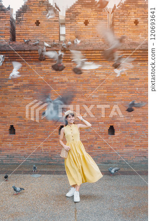 Young asian woman traveler in Yellow dress with hat and bag traveling on Tha Pae Gate, Tourist visit at the old city in Chang Mai, Thailand. Asia Travel, Vacation and summer holiday concept Young asian woman traveler in Yellow dress with hat and bag traveling on Tha Pae Gate, Tourist visit at the old city in Chang Mai, Thailand. Asia Travel, Vacation and summer holiday concept 120693641