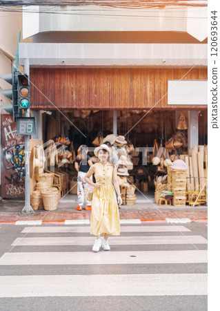Young asian woman traveler in dress with hat traveling to wicker shop on Chang Moi Kao Road, Tourist visit at the old city in Chang Mai, Thailand. Asia Travel, Vacation and summer holiday concept Young asian woman traveler in dress with hat traveling to wicker shop on Chang Moi Kao Road, Tourist visit at the old city in Chang Mai, Thailand. Asia Travel, Vacation and summer holiday concept 120693644