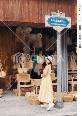 Young asian woman traveler in dress with hat traveling to wicker shop on Chang Moi Kao Road, Tourist visit at the old city in Chang Mai, Thailand. Asia Travel, Vacation and summer holiday concept Young asian woman traveler in dress with hat traveling to wicker shop on Chang Moi Kao Road, Tourist visit at the old city in Chang Mai, Thailand. Asia Travel, Vacation and summer holiday concept 120693648