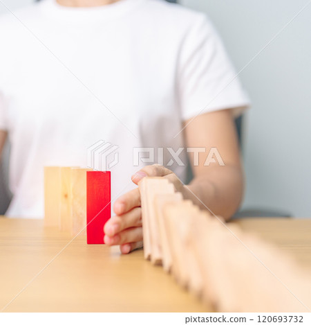 Hand stop falling wood domino blocks on table. Crisis, fall Business, Risk management, Economic recession, Strategy and solutions concept 120693732