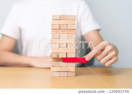 hand pulling wooden block tower on table. Business planning, Risk Management, Solution, leader, strategy, Crisis, falling Business, and Economic recession concept 120693734
