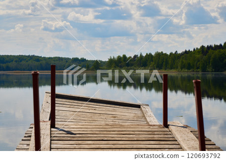 A Serene Wooden Dock Nestled by a Tranquil Lake Under a Beautiful Cloudy Sky Setting A Serene Wooden Dock Nestled by a Tranquil Lake Under a Beautiful Cloudy Sky Setting 120693792