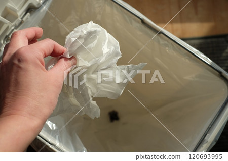 Hand throwing trash in a trash can 120693995