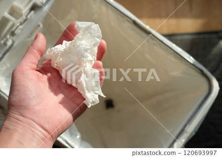 Hand throwing trash in a trash can Hand throwing trash in a trash can 120693997