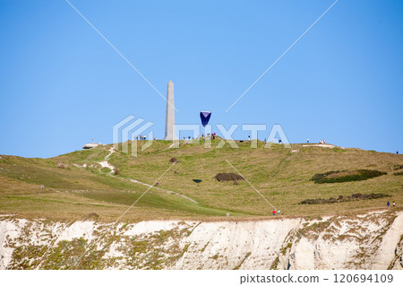 An aerial view showcases the stunning Chalk Cliff landscape, a monument, and a colorful kite An aerial view showcases the stunning Chalk Cliff landscape, a monument, and a colorful kite 120694109