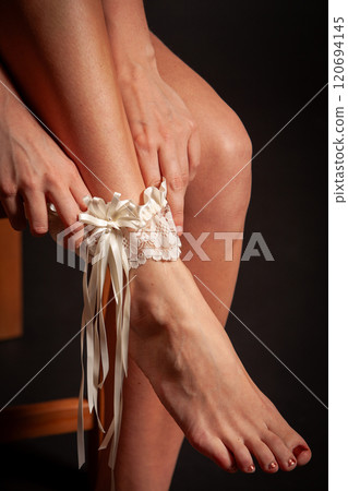 An Exquisite and Elegant Garter Adorned with Beautiful Ribbons on the Models Lovely Shaped Leg 120694145