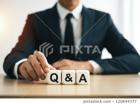 Three white cubes with the word "Q&A" written on them and a man in a black suit 120694377