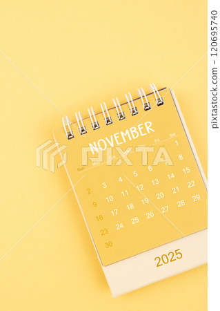 Yellow desktop calendar for November 2025 on a yellow background. Yellow desktop calendar for November 2025 on a yellow background. 120695740