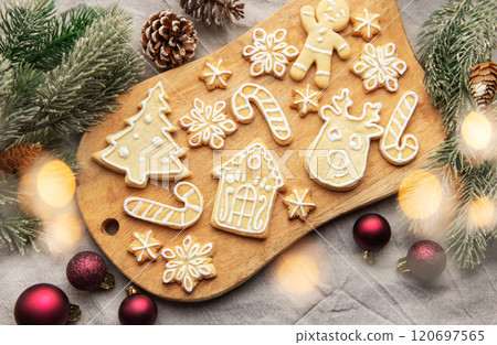 Christmas cookies decorated with icing lying on wooden board Christmas cookies decorated with icing lying on wooden board 120697565