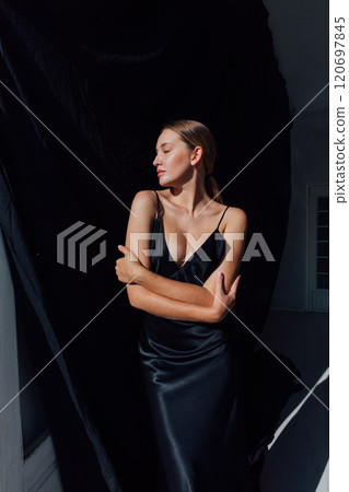 Beautiful fashion woman in black evening silk dress Beautiful fashion woman in black evening silk dress 120697845