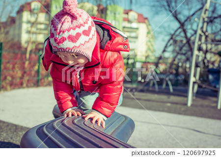 little cute girl playing at the playground in autumn little cute girl playing at the playground in autumn 120697925