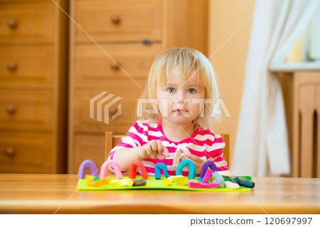 Cute Little girl playing with plasticine at home 120697997