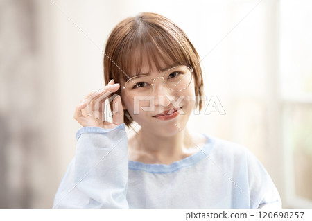 A woman with short bob hair and glasses who has a feminine look 120698257