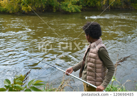 High angle shot of unrecognizable boy fishing while standing on rivers shore High angle shot of unrecognizable boy fishing while standing on rivers shore 120698485