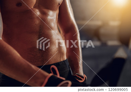 A closeup view of an athletic males welldefined abs while he is in a dynamic workout environment A closeup view of an athletic males welldefined abs while he is in a dynamic workout environment 120699005