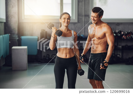 Engaging in an Energetic Workout Session at the Gym Utilizing Dumbbells for Fitness Benefits 120699016