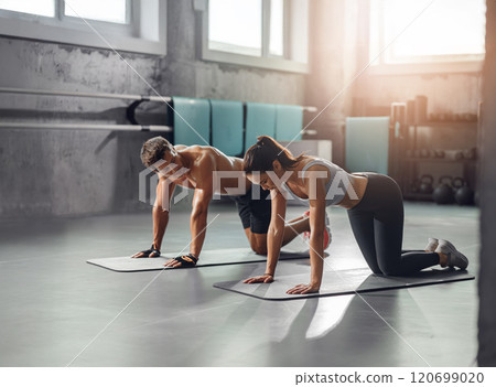 A couple is engaging in a dynamic fitness workout together in a modern gym environment 120699020