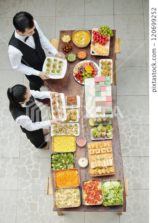 Arranging Colorful Buffet Feast with Various Dishes 120699252
