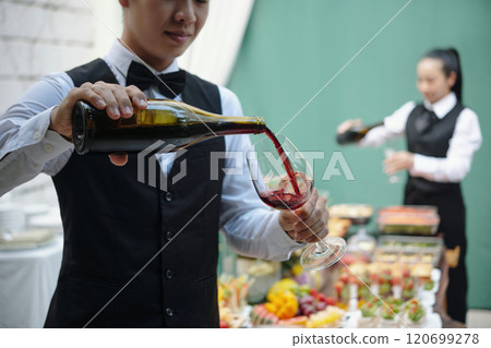 Pouring Red Wine at Elegant Outdoor Event 120699278