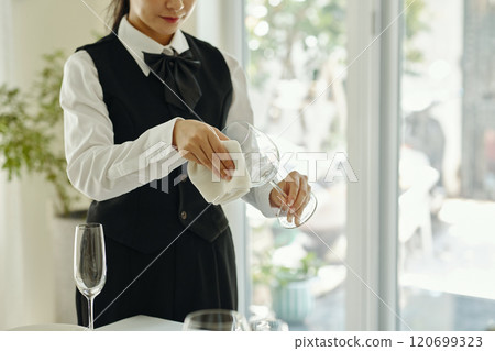 Cleaning Wine Glass in Elegant Dining Setting 120699323