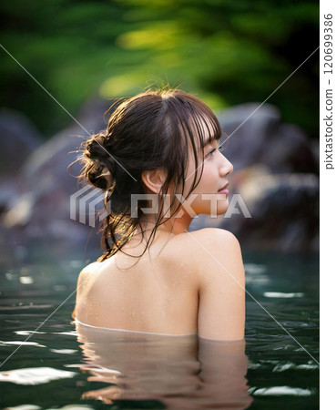 A young woman is soaking in an open-air bath 120699386
