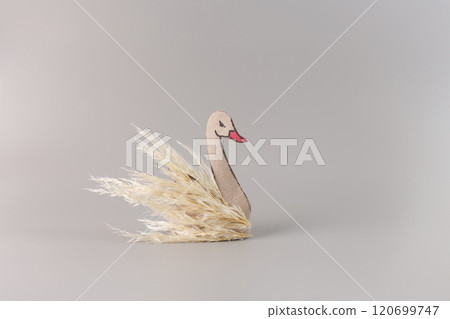 craft swan made of empty toilet paper roll, art project for kids, cylindrical cardboard, recycled creative craft project, pampas grass swan, work in progress, DIY, front view, grey background, 120699747