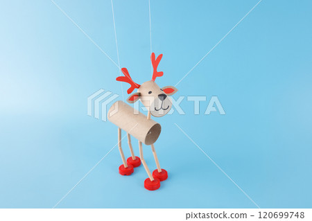 easy activity to do, Christmas reindeer toilet paper roll craft for kid and kindergarten, DIY, marionette from recycled materials, puppet made of cardboard tubes, plastic caps, blue background. easy activity to do, Christmas reindeer toilet paper roll craft for kid and kindergarten, DIY, marionette from recycled materials, puppet made of cardboard tubes, plastic caps, blue background. 120699748