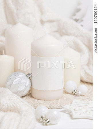 Pillar candle with label near white sweater and Christmas decor and baubles, mockup Pillar candle with label near white sweater and Christmas decor and baubles, mockup 120700164