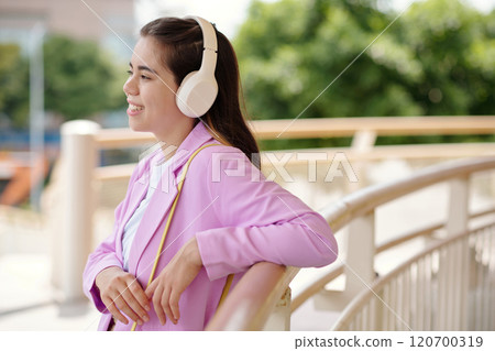 Listening to Music on Headphones Outdoors 120700319