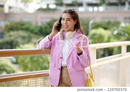 Smiling Woman Using Smartphone While Wearing Headphones Smiling Woman Using Smartphone While Wearing Headphones 120700370