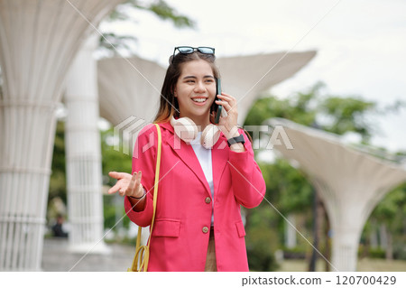 Portrait of Person Talking on Mobile Phone Smiling Outdoors 120700429
