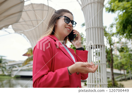 Talking on Mobile Phone Outdoors Wearing Sunglasses 120700449