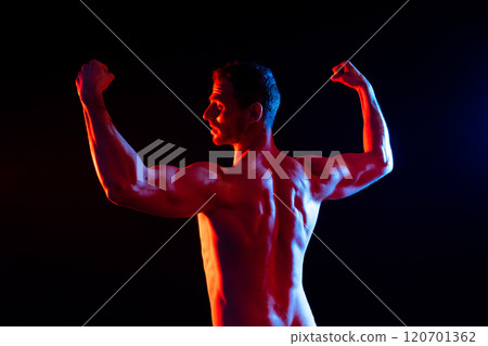 Image of muscle man posing in studio, dark white red background Image of muscle man posing in studio, dark white red background 120701362