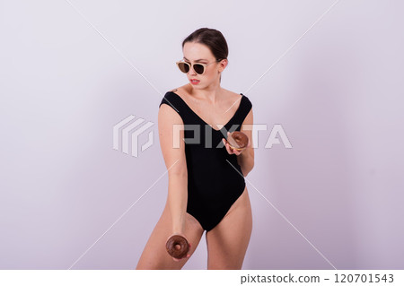 Plus size seductive model female, fashionable blonde in black bodysuit with donut 120701543