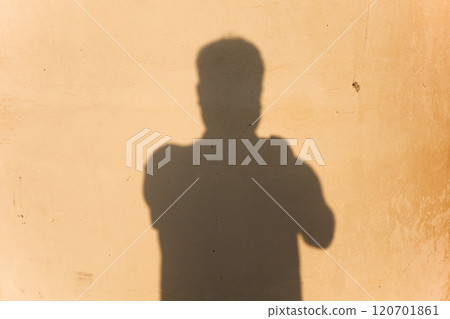 Man taking a picture of his shadow on the wall, photographer's shadow 120701861