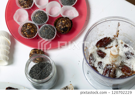 Dried fruit sweets. Balls of prunes, dates and coconut. With a sprinkle of black sesame powder. Dried fruit sweets. Balls of prunes, dates and coconut. With a sprinkle of black sesame powder. 120702229