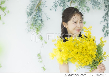 Young woman holding a bouquet of mimosa Young woman holding a bouquet of mimosa 120702416