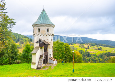 Slikovka Tower stands prominently in the Ore Mountains, showcasing its medieval architecture amidst a lush green landscape. The serene location attracts visitors year-round. 120702706
