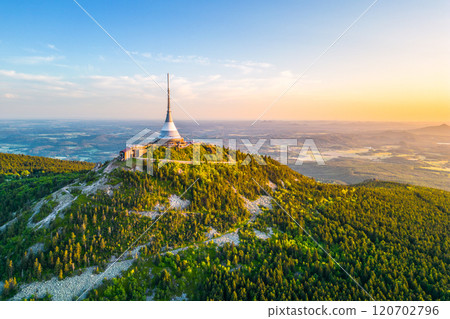 The captivating aerial view showcases Jested mountain with its distinctive hotel and TV transmitter, surrounded by lush greenery and the expansive landscape of Liberec, Czechia. 120702796
