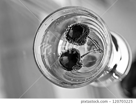 Black and white image of cherries submerged in glass, surrounded by bubbles, creating a dramatic visual Black and white image of cherries submerged in glass, surrounded by bubbles, creating a dramatic visual 120703225